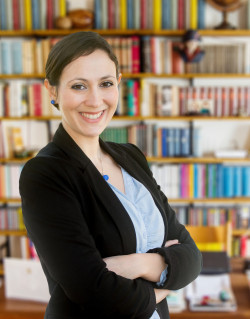 smiling female administrator in front of bookcases